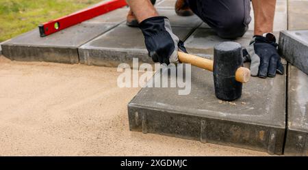 Mann, der Betonplatten für die Terrasse legt Stockfoto