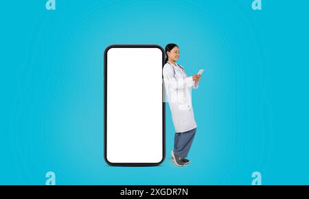 Frau Doktor Und Smartphone Mit Leerem Bildschirm Vor Blauem Hintergrund Stockfoto
