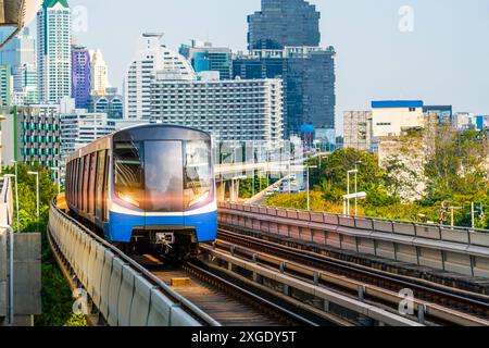 Elektrische Bahn helle leichte Eisenbahnwagen rasen die Fahrt entlang der Route im Sonnenuntergang Himmel Eisenbahnbrücke Viadukt zwischen der modernen Stadt der Gebäude, SK Stockfoto