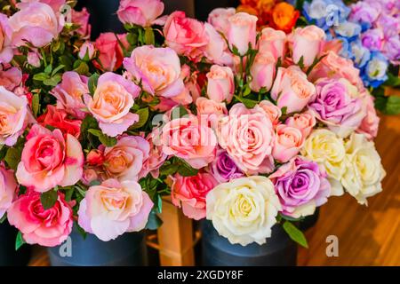 Zusammensetzung aus scharlachrosa Rosen Kunstblumen aus hochwertigem Kunststoff, imitiert natürliche echte Tarnung. Stockfoto