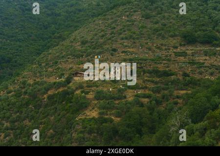 Ein malerischer Blick auf ein Bauernhaus in einem grünen Hügel, das die Schönheit des ländlichen mediterranen Lebens zeigt. Stockfoto