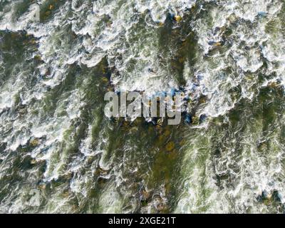 Drohnenblick auf die Stromschnellen des Flusses Save, die über untergetauchte Felsen auf dem Boden fließen und weiße Spritzer und Schaum erzeugen Stockfoto