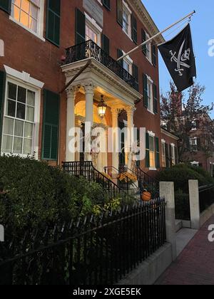 Am Eingang eines historischen Hauses in Salem Massachusetts hängt nachts eine Piratenfahne, ein paar Tage vor Halloween Stockfoto