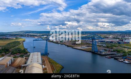 Eine Luftaufnahme der Tees Transporter Bridge zwischen Middlesbrough und Port Clarence, die 1911 eröffnet wurde. Die Brücke trägt eine Gondel, die Fahrzeuge und Fußgänger über den Fluss Tees transportieren soll. Die Brücke ist jedoch seit 2019 aus Sicherheitsgründen geschlossen. Aufgrund seines Alters und seiner historischen Art und Weise, in der er gebaut wurde, sind die erforderlichen Inspektionen und baulichen Bewertungen äußerst technischer Natur. Im Januar 2024 genehmigte das Tees Valley Combined Authority Cabinet einen Bericht, der 30 Millionen Pfund für die Wiederinbetriebnahme der Brücke verpflichtete. Juli 2024 Stockfoto