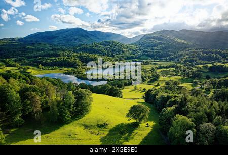 Lake District National Park Landschaft. S.W. über Elterwater von Neaum Crag, Langdale, zum Wetherlam Mountain und zum Wrynose Pass. Sommerabend Stockfoto