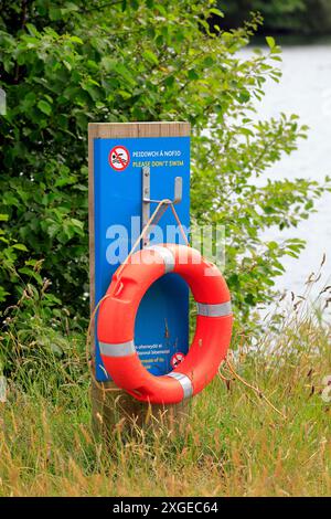 Bitte schwimmen Sie nicht Schild und Schwimmvorrichtung für den Rettungsgurt, Cosmeston Lakes and Country Park, Penarth, Cardiff, South Wales. Vom Juli 2024 Stockfoto