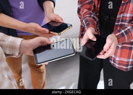 Leute, die Smartphones mit leeren Bildschirmen in Innenräumen halten, Nahaufnahme Stockfoto
