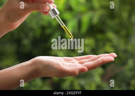 Frau tropft im Freien ätherisches Öl aus der Pipette, Nahaufnahme Stockfoto