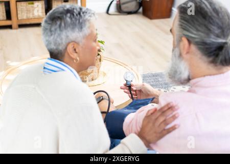 Blutdruck überprüfen, Seniorenpaar überwachen gemeinsam die Gesundheit zu Hause Stockfoto