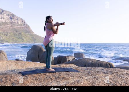 Draußen auf dem Meer trainieren, Frau dehnt sich auf Yogamatte, Kopierraum Stockfoto