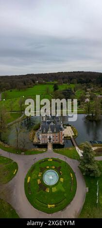 Huizingen, Belgien, 26. März 2024, europäisches Herrenhaus an einem friedlichen See, umgeben von grünen Feldern in einer ruhigen und malerischen Umgebung Stockfoto