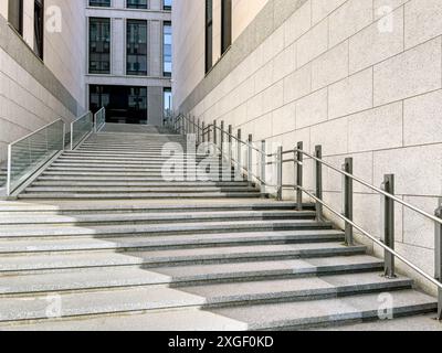 Eingang des modernen Bürogebäudes. Granittreppe mit Handlauf aus Edelstahl. Vorderansicht. Stockfoto