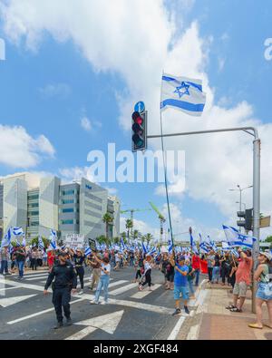 Haifa, Israel - 07. Juli 2024: Menschen protestieren mit Fahnen, verschiedenen Schildern, die eine große Kreuzung blockieren. Teil des Tages der Störung gegen die Regierung A Stockfoto