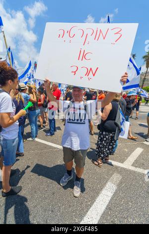 Haifa, Israel - 07. Juli 2024: Menschen protestieren mit Fahnen, verschiedenen Schildern, die eine große Kreuzung blockieren. Teil des Tages der Störung gegen die Regierung A Stockfoto