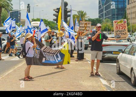 Haifa, Israel - 07. Juli 2024: Menschen protestieren mit Fahnen, verschiedenen Schildern, die eine große Kreuzung blockieren. Teil des Tages der Störung gegen die Regierung A Stockfoto