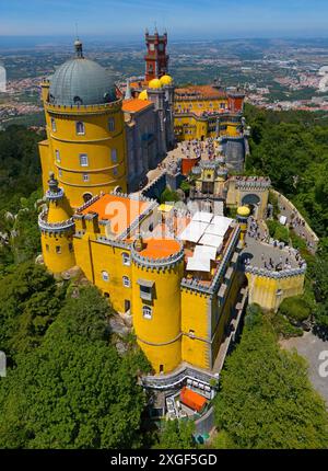 Historisches Schloss in Gelb auf einem Hügel mit einer beeindruckenden Aussicht und umgeben von Wald, Blick aus der Luft, Palacio Nacional da Pena, Nationalpalast Pena Stockfoto