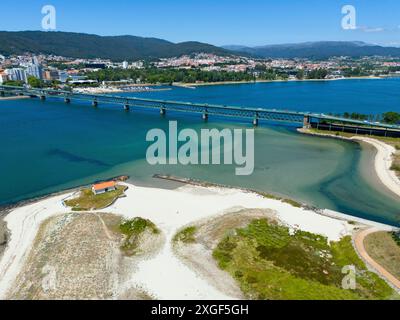 Blick auf eine Küstenstadt mit einer Brücke über einen Fluss, der in das Meer fließt, umgeben von Hügeln und weißem Sandstrand, Blick aus der Luft, Ponte Eiffel Stockfoto