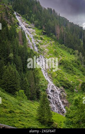 Hoher Wasserfall, der über eine steile bewaldete Bergwand fließt, Stilluptal, Zillertal. Österreich Stockfoto