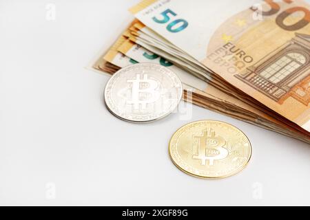 Bitcoin-Münzen und Euro-Banknoten. Kryptowährung im Vergleich zu fiat Money Concept Stockfoto