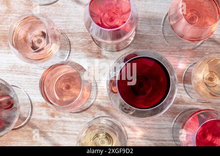 Weinauswahl. Weiß, Rose und Rotwein in vielen Gläsern, Decke flach auf einem hölzernen Hintergrund erschossen Stockfoto