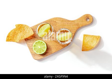 Tequila-Aufnahmen mit Limetten und Nachos, Top-Aufnahme auf weißem Hintergrund Stockfoto