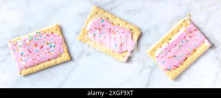 Panorama-Banner mit Erdbeeren-Pop-Tart auf weißem Marmorhintergrund. Rosafarbenes Toaster-Gebäck Stockfoto