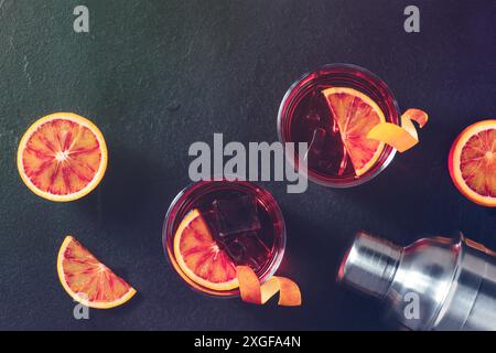 Orangefarbene Cocktails, getöntes atmosphärisches Bild, mit Blutorangen und einem Shaker, über Kopf mit Copyspace Stockfoto