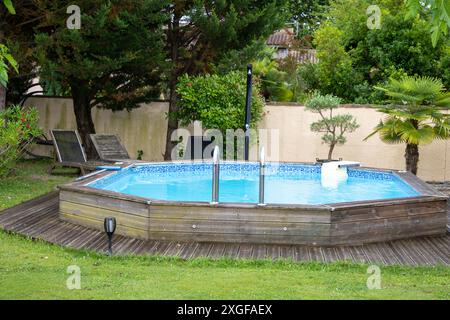 Swimmingpool im Hinterhof mit Gartenmöbeln im Garten Stockfoto