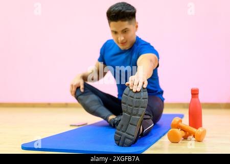 Portrait eines Fitness-Mannes, der Stretching-Übungen im Fitnessstudio macht. Hochwertige Fotos Stockfoto