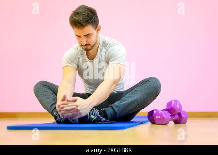 Portrait eines Fitness-Mannes, der Stretching-Übungen im Fitnessstudio macht. Hochwertige Fotos Stockfoto