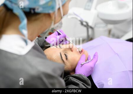 Zahnarzt Hygienist, die orale hygienische Reinigung in der Zahnmedizin für junge Frau. Mit professionellen elektrischen Geräten Zahnbohrmaschine zu bürsten Stockfoto