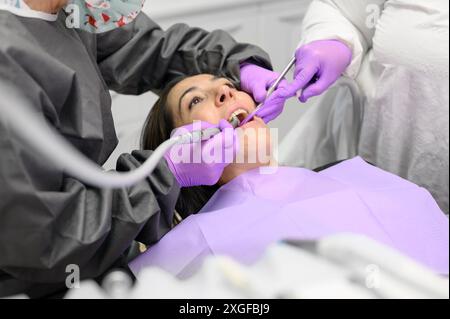 Zahnarzt Hygienist, die orale hygienische Reinigung in der Zahnmedizin für junge Frau. Mit professionellen elektrischen Geräten Zahnbohrmaschine zu bürsten Stockfoto