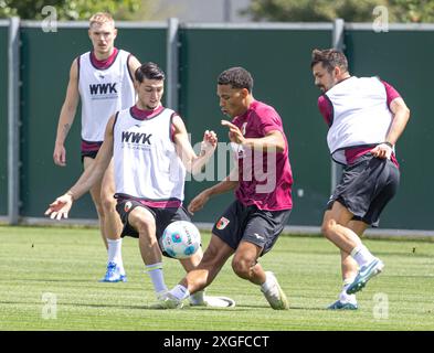 Kampf um den Ball zwischen Yusuf Kabadayi (FC Augsburg, li.) und Henri Koudossou, David Colina (re.); FC Augsburg, Training, Stockfoto