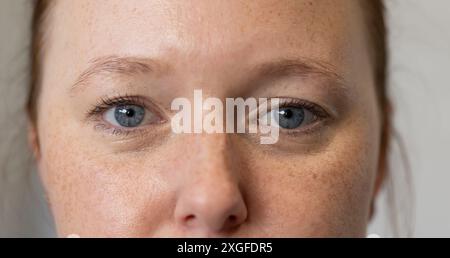 Nahaufnahme einer Frau mit blauen Augen, fokussiert auf Gesichtszüge Stockfoto