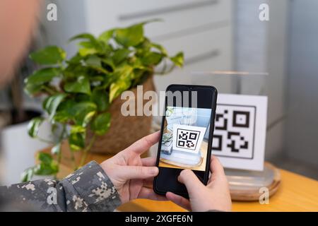 Scannen des QR-Codes mit Smartphone, Person in medizinischer Klinik Stockfoto