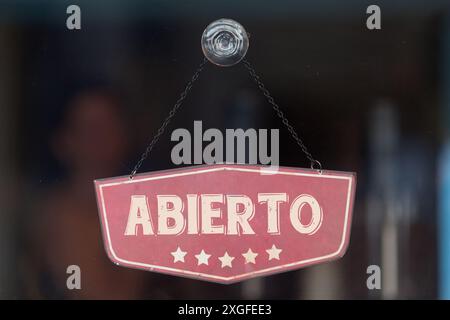 Altmodisches Schild im Fenster eines Ladens mit der Aufschrift auf Spanisch 'Abierto', auf englisch 'Open'. Stockfoto