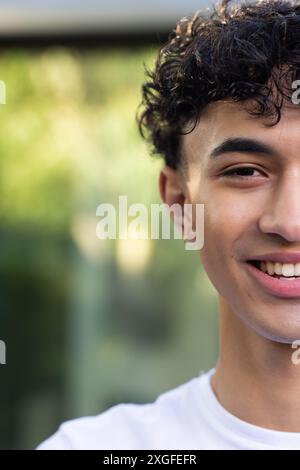 Lächelnder junger Mann mit lockigem Haar, weißes Hemd, Nahporträt Stockfoto