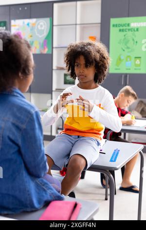 Glückliche, vielfältige Schulkinder, die Gebärdensprache im Schulunterricht benutzen Stockfoto