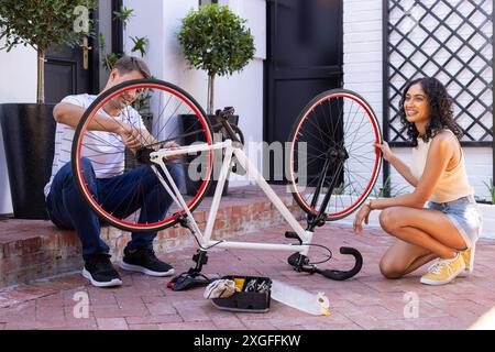 Gemeinsam Fahrrad reparieren, junges Paar, das an sonnigen Tagen Outdoor-Aktivitäten genießt Stockfoto