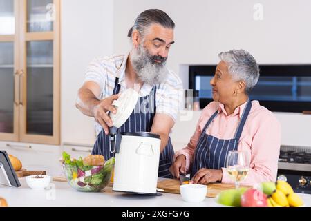 Zusammen kochen, Seniorenpaar, die Mahlzeit mit Reiskocher und frischem Gemüse zubereiten Stockfoto