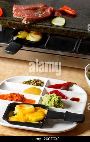 Schmelzender Käse in einem Raclette Stockfoto