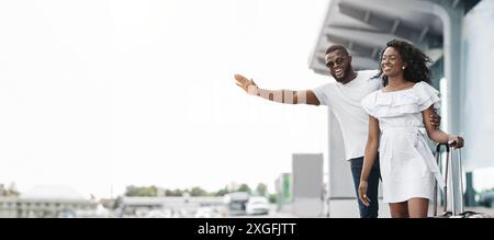Glückliches Paar, das am Flughafenterminal auf Wiedersehen winkt Stockfoto