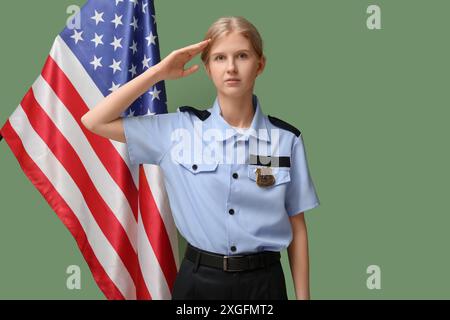 Grüßt Polizistin und Flagge der USA auf grünem Hintergrund Stockfoto