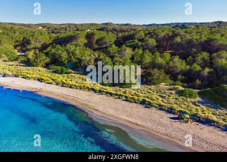 Aus der Vogelperspektive auf den Strand es Grau auf Menorca an einem sonnigen Sommertag. Unberührter Strand mit blauem, sauberem Wasser, Drohnenlandschaft der baleareninsel Menorc Stockfoto