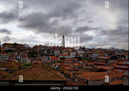 Ein Panoramablick auf die Dächer von porto unter einem bewölkten, grauen Himmel, mit dem berühmten clerigos-Turm, der sich über der historischen Stadtlandschaft erhebt Stockfoto