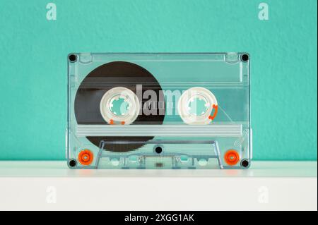 Transparente Audiokassetten liegen auf einem weißen Regal und erinnern an die Vergangenheit und den ikonischen Sound der 80er und 90er Jahre Stockfoto