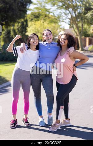 Im Freien trainieren, drei Freundinnen in Activewear lächeln und posieren zusammen Stockfoto
