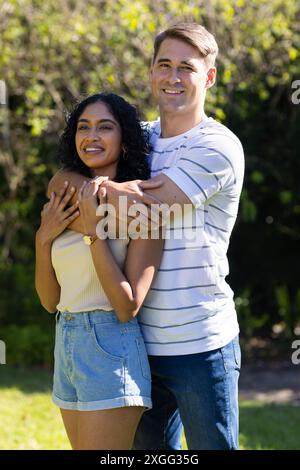 Junges Paar, das draußen lächelt und den sonnigen Tag zusammen genießt Stockfoto