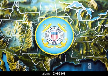 KIEW, UKRAINE - 26. JUNI 2024 Wappen der US-Küstenwache auf Papierkarte der Vereinigten Staaten von Amerika Stockfoto