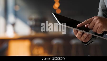 Geschäftsmann hält ein Modell. IPad Digital Tablet Multitasking im Internet im Café Stockfoto